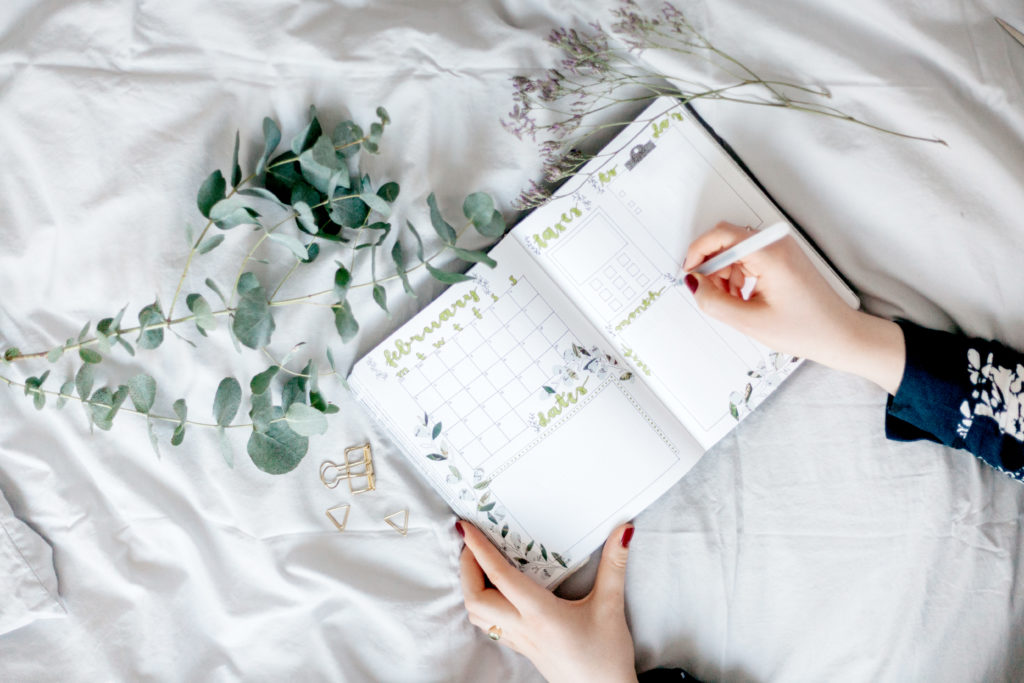 bullet_journal_wishlist femme écrit sur un carnet de note